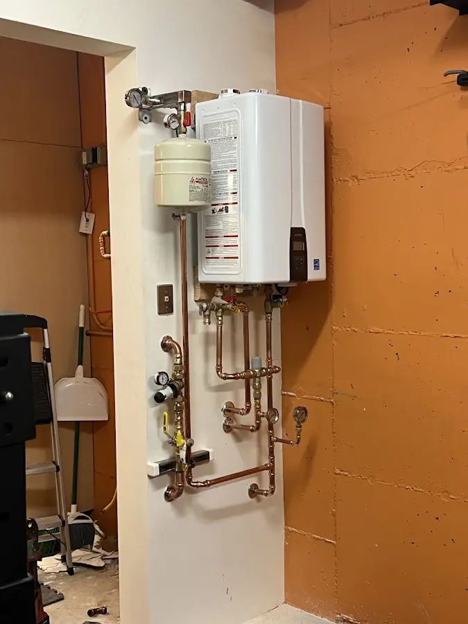 Plumbing technician inspecting water heater connections in Reedley